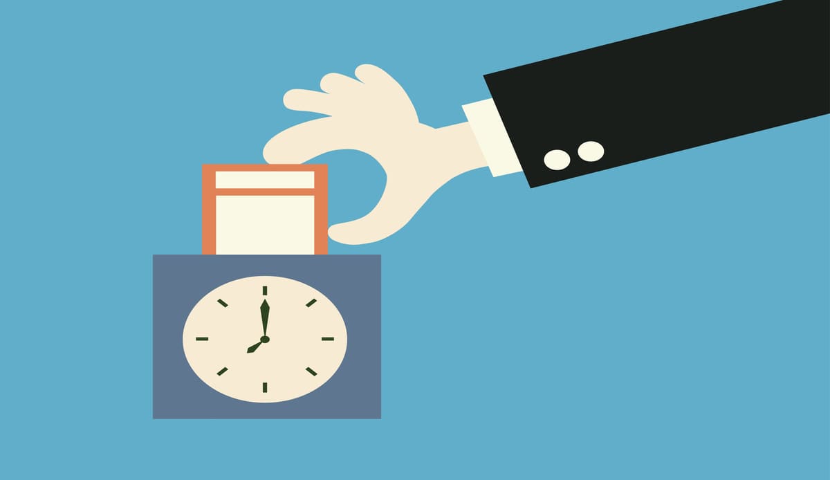 タイムカードを打刻機に入れている