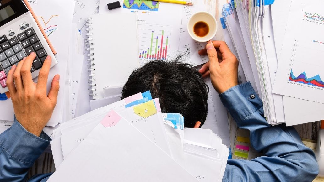 書類に埋もれる男性