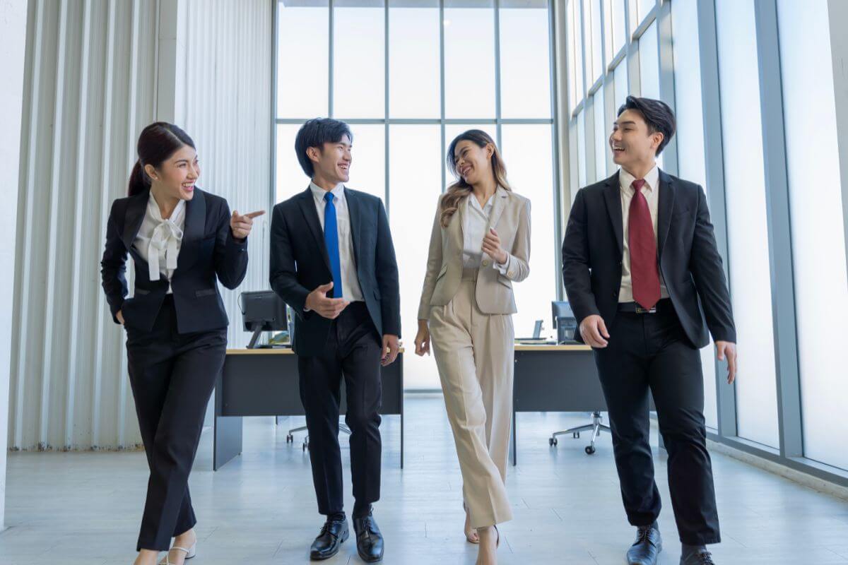 明るく会話をするアジアの若いビジネスマンのグループ