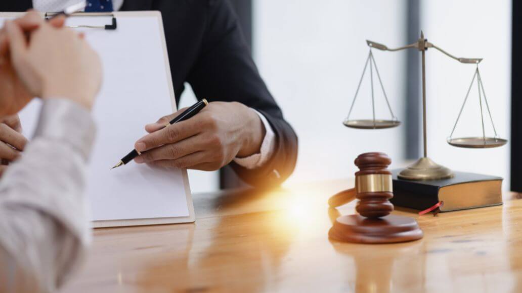 法廷の机の上にある契約書類と木製の小槌