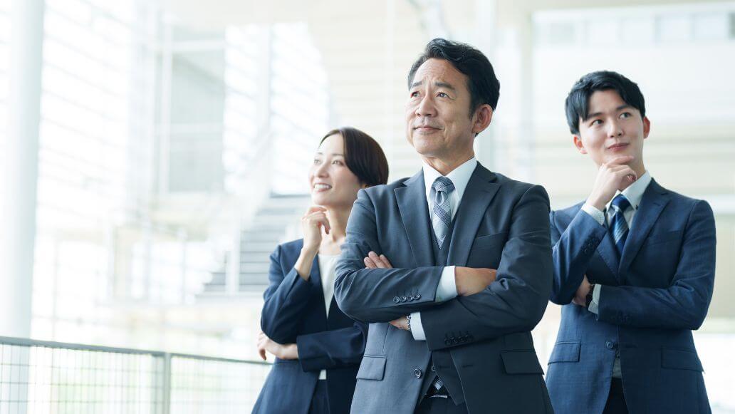 オフィスの廊下で一緒に考えているアジアのビジネスパーソンのグループのポートレート