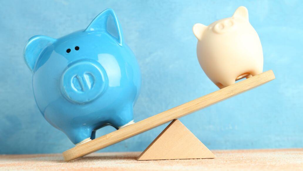 サイズの異なる豚の貯金箱がスケールの不均衡を示す