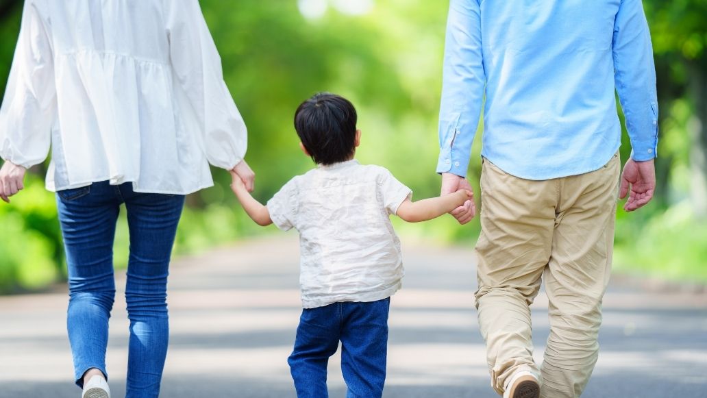 手をつないで歩く親子