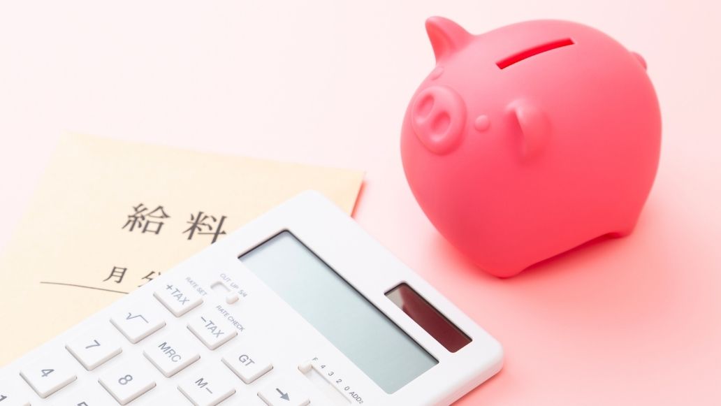 電卓と給与袋と貯金箱