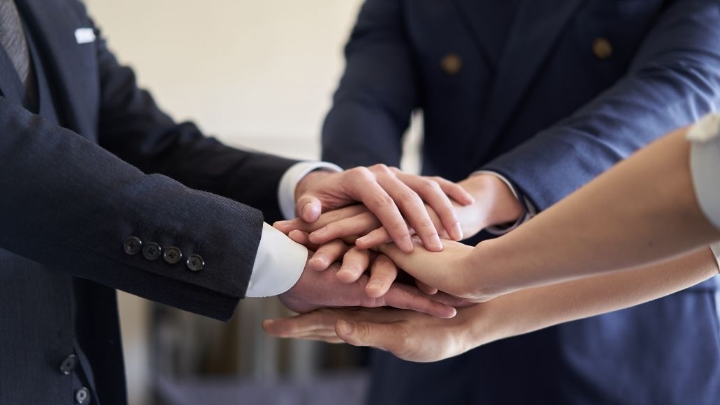 手を重ねる人々