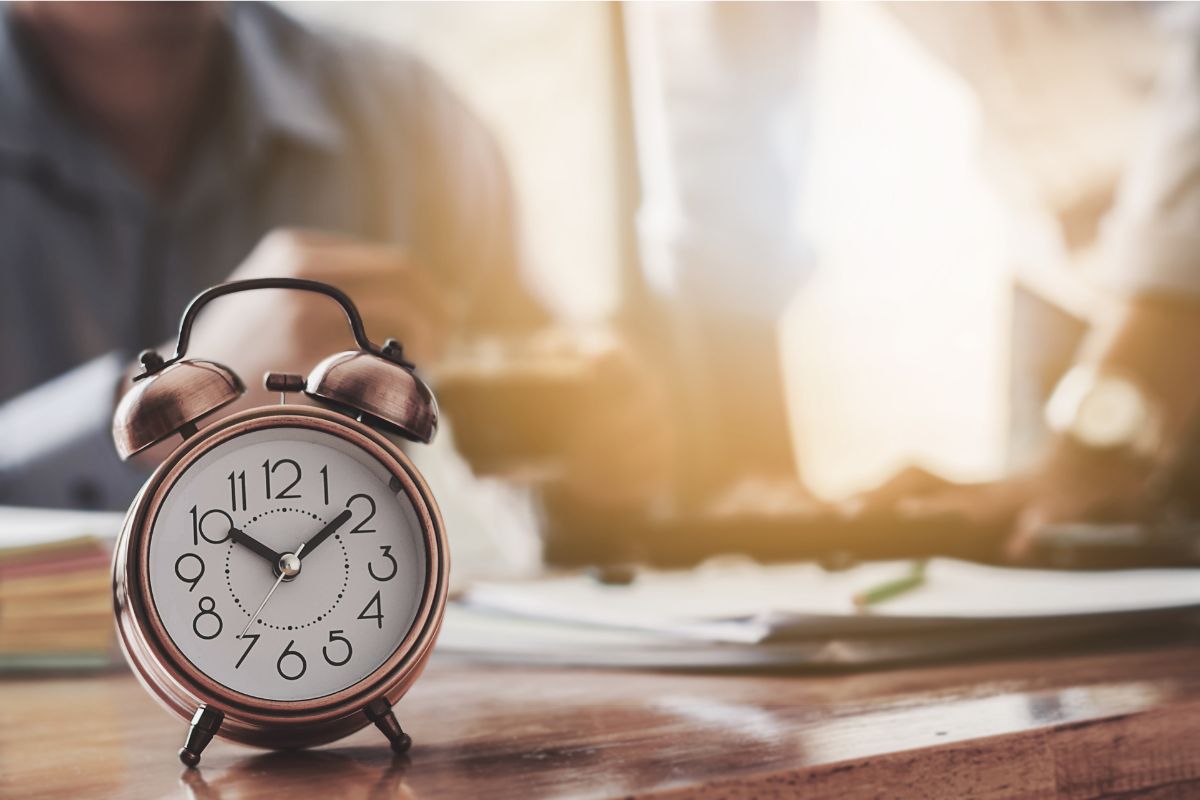 オフィスで働くビジネスパーソンと時計