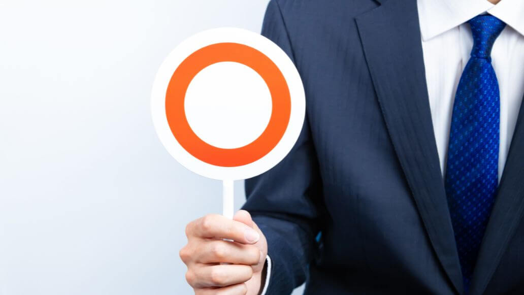 丸の札を持つスーツのビジネスパーソン