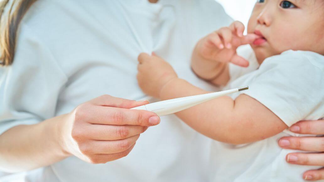 体調不良の子どもを抱く女性