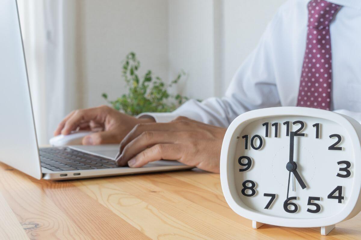 スーツで働く人と時計