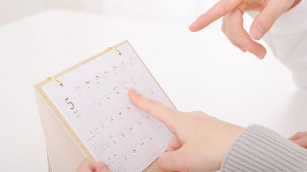 カレンダーを指差す男女