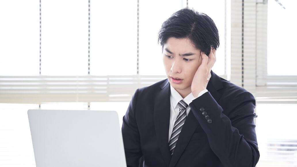 PCを見て顔をしかめる男性