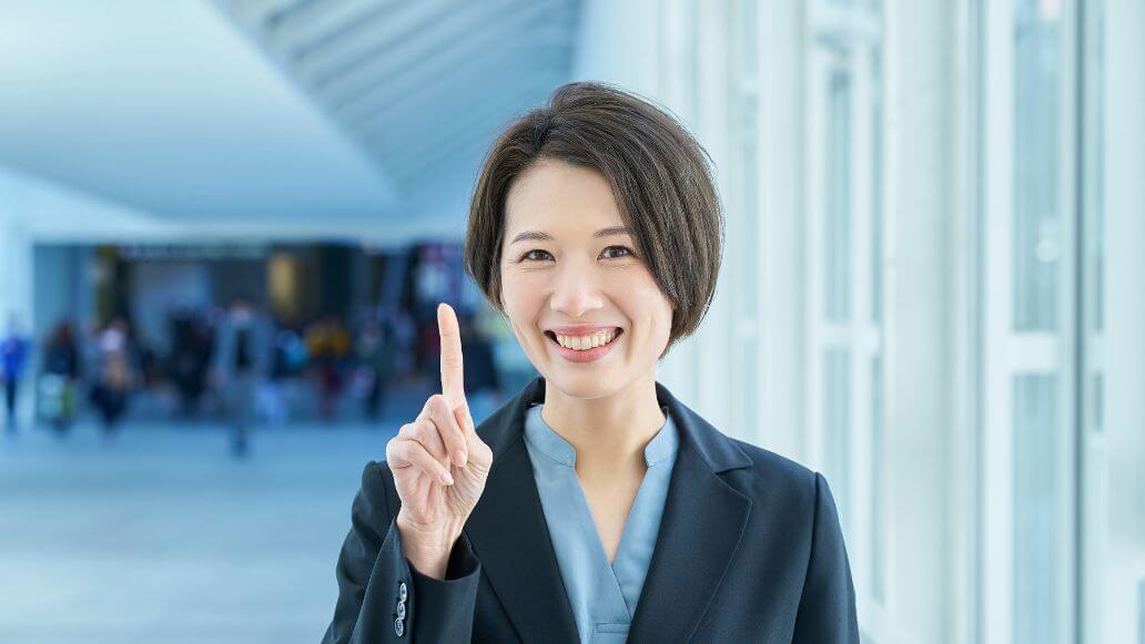 人差し指を上げてポーズをとるビジネスパーソン