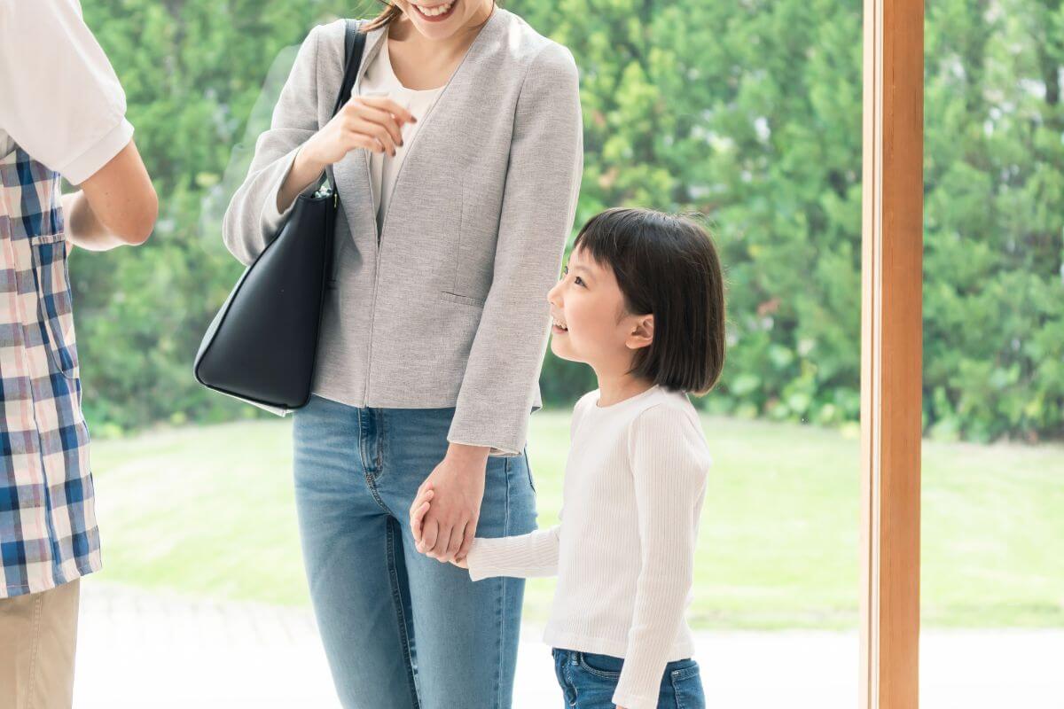 仕事帰りに保育園へ子どもを迎えに行く母親