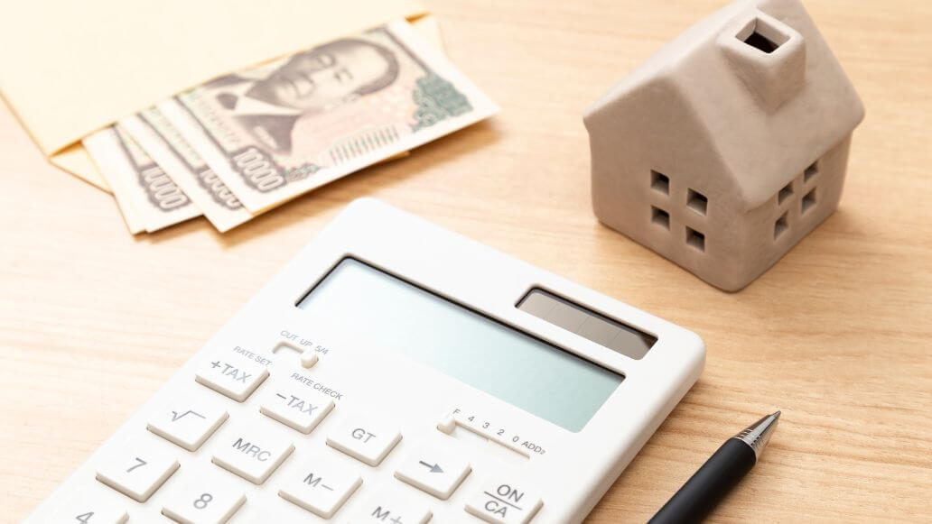 日本円と電卓、家のモチーフ