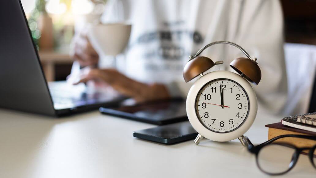 オフィスのデスク上で12時を指す時計