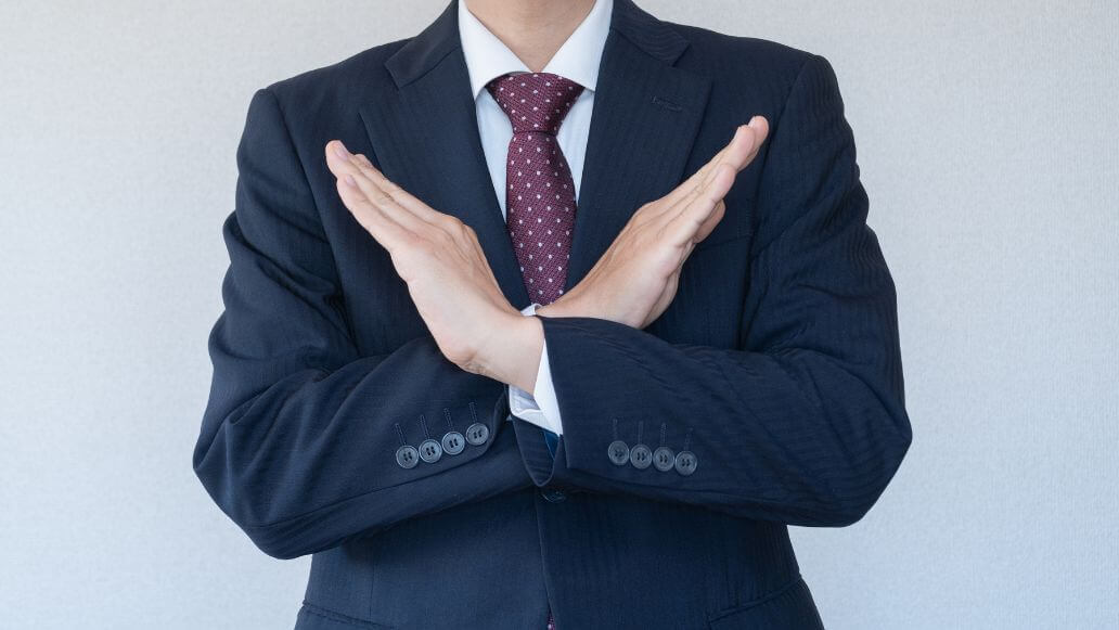 断るポーズの男性