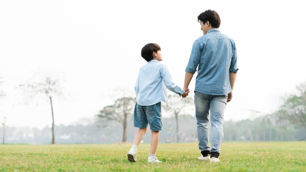公園で手をつないで歩く親子