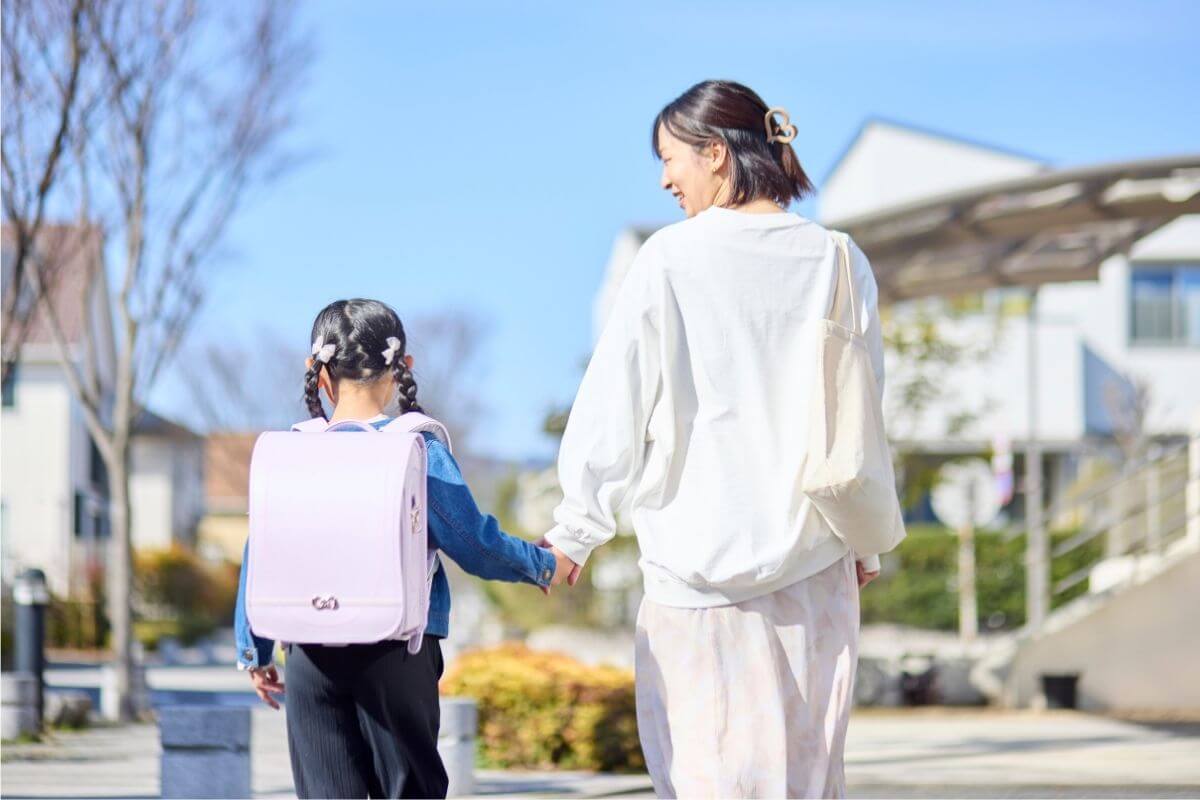 住宅街を手をつないで歩く親子
